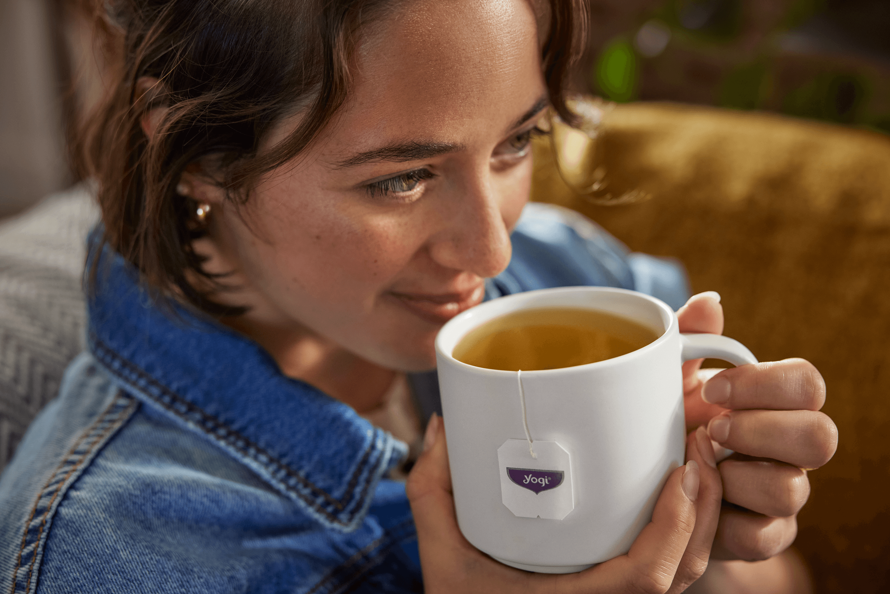 Woman smiling and drinking a cup of Yogi Tea